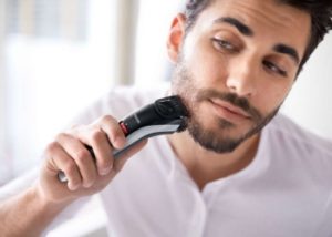 Homme utilisant sa tondeuse à barbe Philips QT4013/16